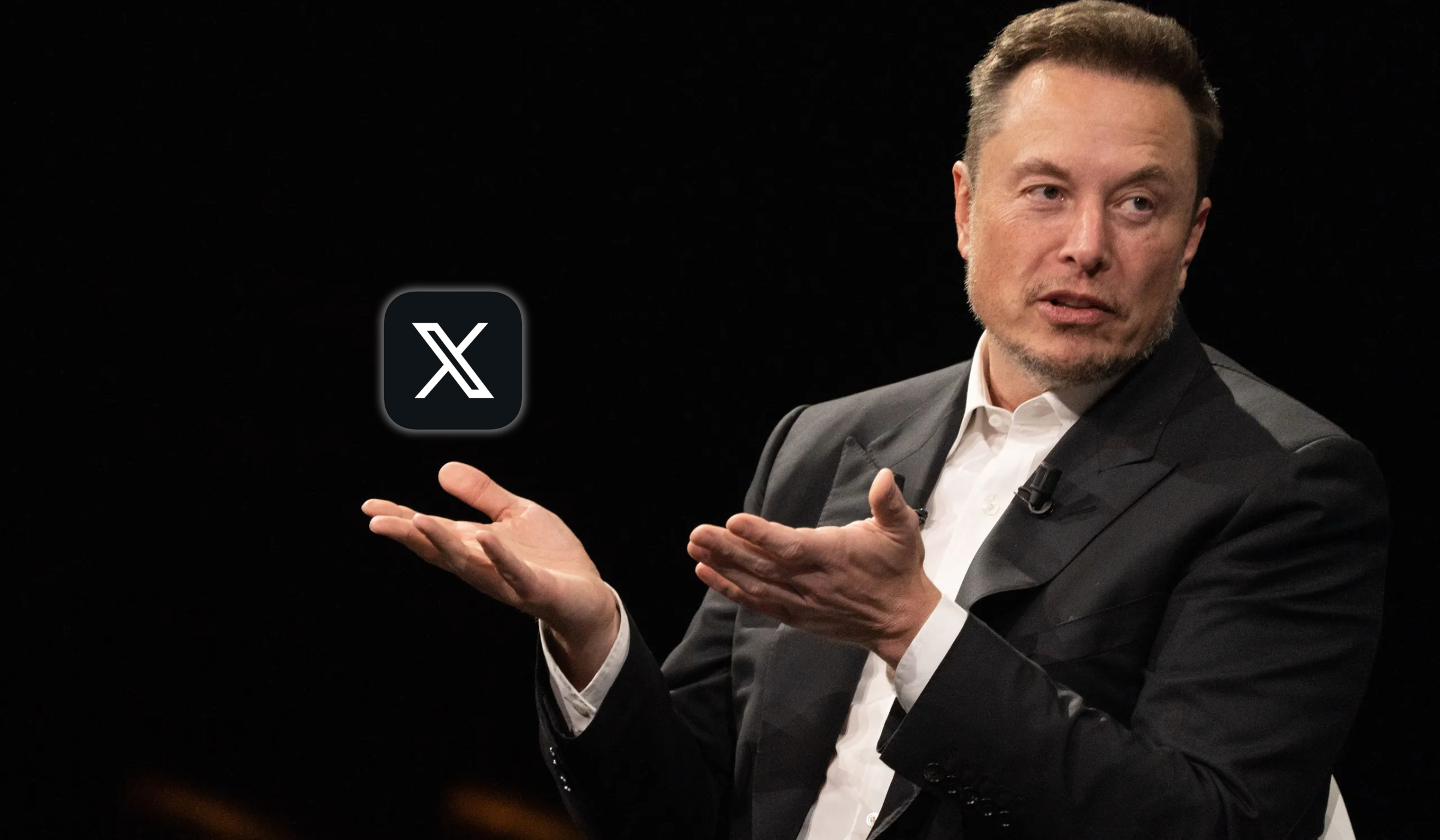 Photo of X owner Elon Musk holding the platform's logo in his hand.